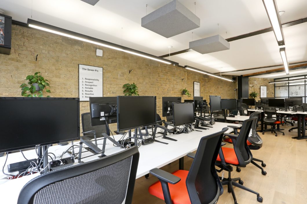row of hot desking spaces in office