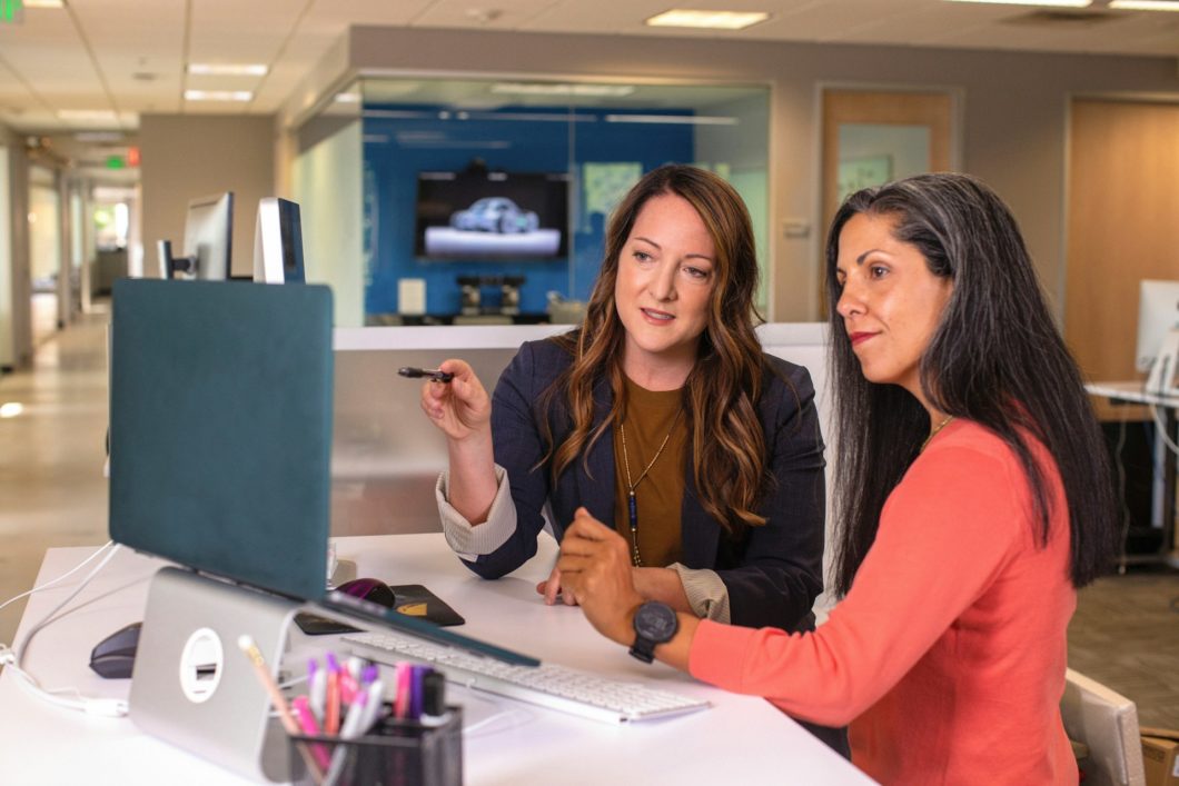two women chatting at a computer